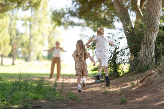 Kids playing and running through a sunny forest path