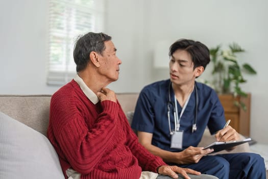 A nurse listens attentively to an elderly patient as he discusses health issues, fostering open communication in a home healthcare setting.