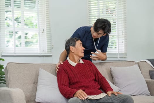 A nurse offers compassionate support to an elderly patient in a cozy home setting, fostering trust and communication in healthcare.