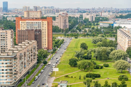 Aerial view of a green park dividing residential buildings and a busy road with traffic in moscow, russia, offering a tranquil space amidst urban activity