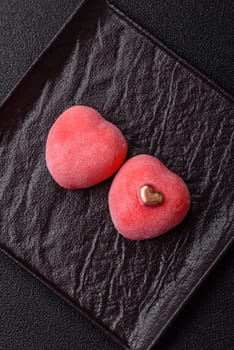 Delicious sweet mochi in the shape of red hearts for the holiday of Valentine's Day