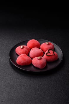 Delicious sweet mochi in the shape of red hearts for the holiday of Valentine's Day