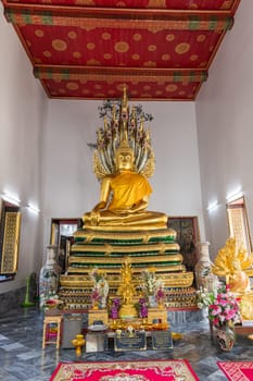 The peaceful interior has a majestic Buddha statue and colorful murals in a calming temple atmosphere