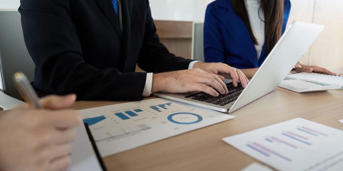 A diverse business team focusing on data analysis and engaging in discussion, showcasing teamwork and professionalism in a contemporary workspace.
