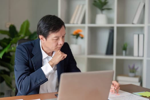 An elderly businessman deeply engaged in strategy planning highlighting the importance of experience in today's business landscape.