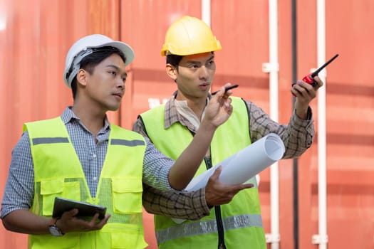 Two logistics engineers discuss container management strategies to enhance efficiency in a warehouse environment.