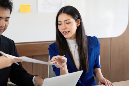 A diverse business team actively discussing analysis and reviewing documents, highlighting effective communication and teamwork in a professional office environment.