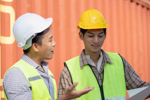 Engineers discuss logistics solutions at a container terminal enhancing efficiency and collaboration in shipping operations.