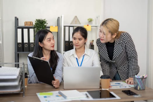 Three colleagues engage in a productive discussion showcasing teamwork and collaborative problem-solving in a modern office environment.