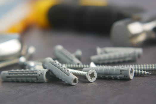 Close-up view of screws and anchors on a workspace, well organized for use.