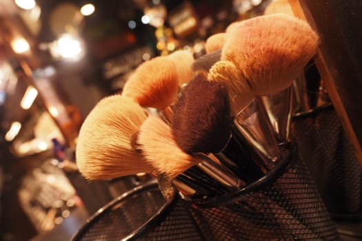 Various makeup brushes sit ready for use in a vibrant studio setting.