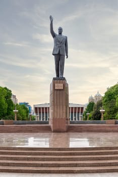 Baku, Azerbaijan - May 5, 2024: Brass statue of Heydar Aliyev, dedicated to the former Azerbaijani President, in Heydar Aliyev Square, in front of a palace that bears the president name