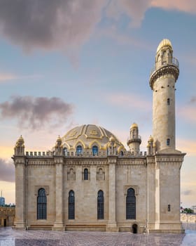 Majestic Taza Pir Mosque in Baku, Azerbaijan, is bathed in a peaceful early evening sky, showcasing its intricate architecture with twin minarets