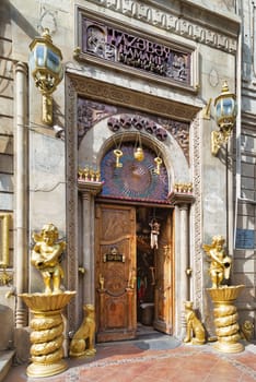 Baku, Azerbaijan - May 6, 2024: The ornate entrance of Tazabay Hamami, a bathhouse, is adorned with golden sculptures and intricate designs, creating an inviting ambiance for relaxation