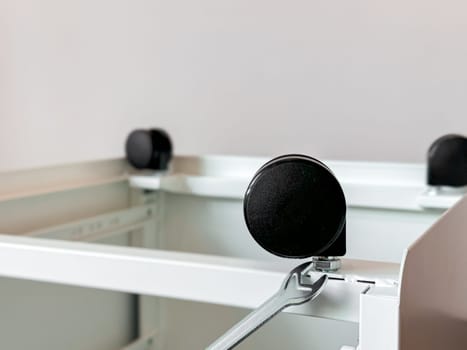 Close up view of office furniture caster wheels on metal frame.