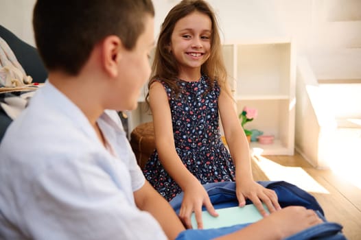 Two children enjoying a moment of learning and interaction. Featuring a positive atmosphere of joy and curiosity in a home setting.