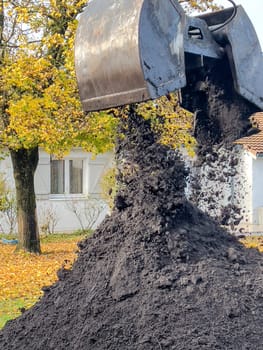 France, Gironde, December 2024, Delivery of topsoil by truck crane to the garden of a residential house. High quality photo