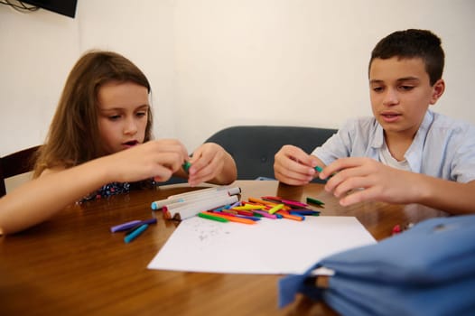 Two children enjoy a creative art activity, focusing on using colorful materials and stationery.