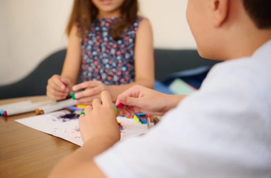 Children engaging in creative crafting activity with colorful materials on a table, fostering teamwork.