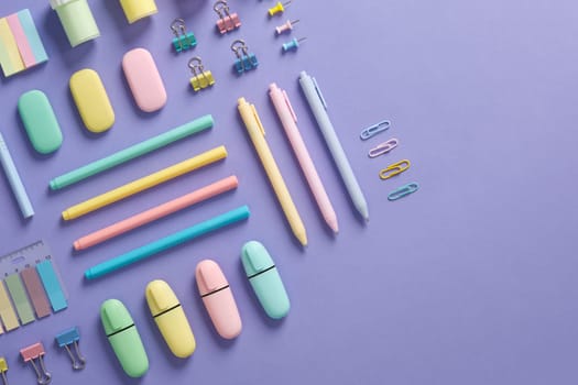 Stationery banner in green, yellow, pink and blue pastel colors on light purple background. Space for your text.