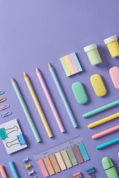 Stationery banner in green, yellow, pink and blue pastel colors on light purple background. Space for your text.
