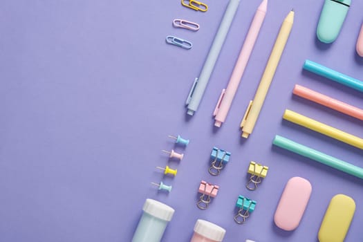 Stationery banner in green, yellow, pink and blue pastel colors on light purple background. Space for your text.