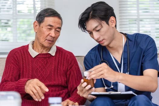 A attentive nurse guides an elderly man, explaining medication dosage from a clearly labeled bottle, ensuring his understanding and safety during home care.