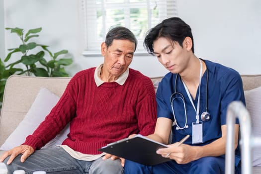 A thoughtful nurse records essential health information as an elderly man attentively listens, fostering effective communication in a home care environment.