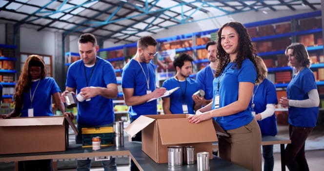 Diverse volunteers at charity foundation pack food donations for community.