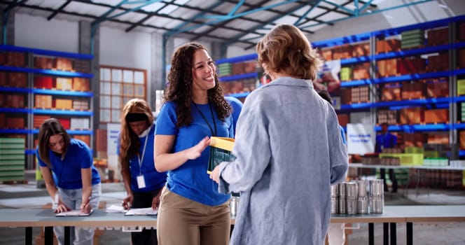 Kind-hearted volunteer provides food to homeless woman at charity center.