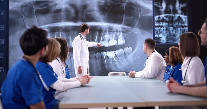 Medical professionals discussing x-ray results during team presentation in clinic.