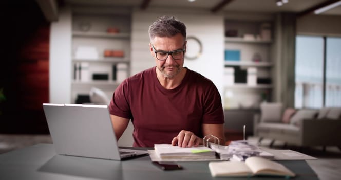 Man Doing Taxes And Family Budget On Computer