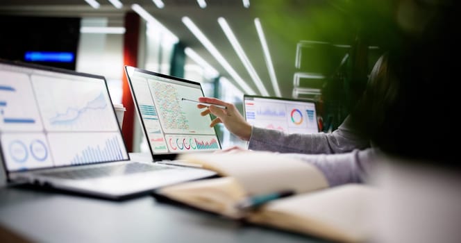 Young woman managing financial data on laptop in modern office.