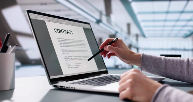 Busy executive insuring trust with legal paperwork on laptop computer.