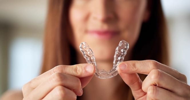 Young Woman Putting On Clear Aligner Dental Night Guard