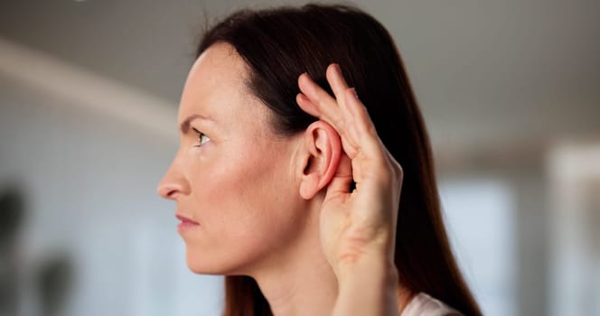 Audiologist aids woman with hearing damage and ear problems.