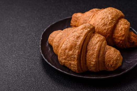 Sweet crispy croissants with chocolate filling on a dark concrete background