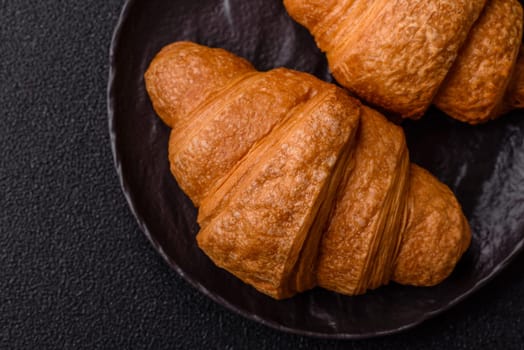 Sweet crispy croissants with chocolate filling on a dark concrete background