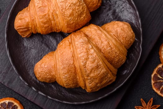 Sweet crispy croissants with chocolate filling on a dark concrete background