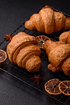 Sweet crispy croissants with chocolate filling on a dark concrete background