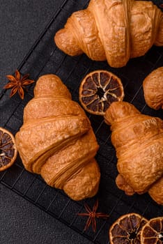 Sweet crispy croissants with chocolate filling on a dark concrete background