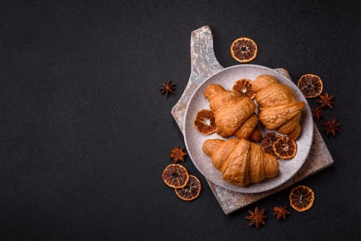 Sweet crispy croissants with chocolate filling on a dark concrete background