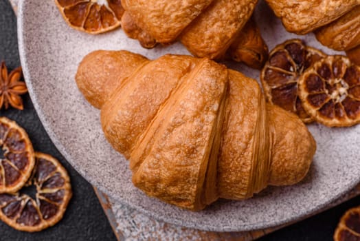 Sweet crispy croissants with chocolate filling on a dark concrete background