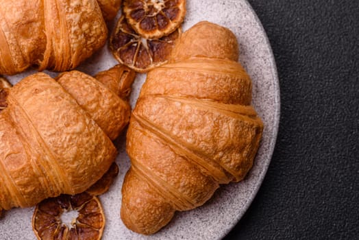 Sweet crispy croissants with chocolate filling on a dark concrete background