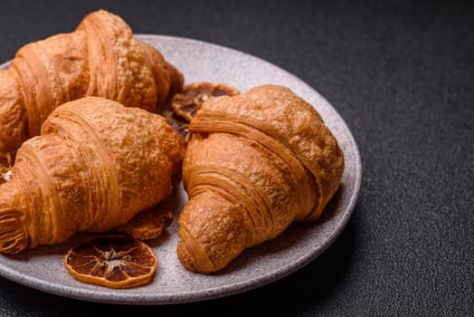 Sweet crispy croissants with chocolate filling on a dark concrete background
