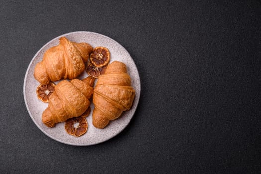 Sweet crispy croissants with chocolate filling on a dark concrete background