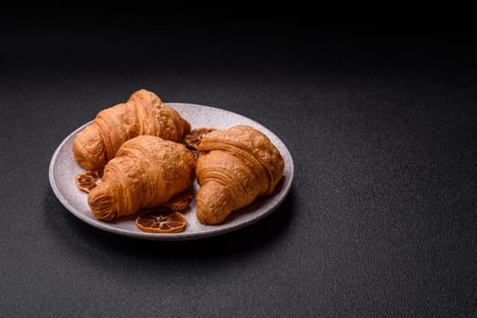 Sweet crispy croissants with chocolate filling on a dark concrete background