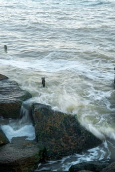 there is a storm at sea. sea waves are beating against the rocks. the photo was taken with a long exposure