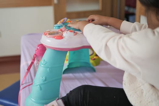Young child engages with interactive play table in educational space.