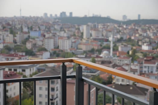 Overlooking a vast urban area from a balcony in a tall building.